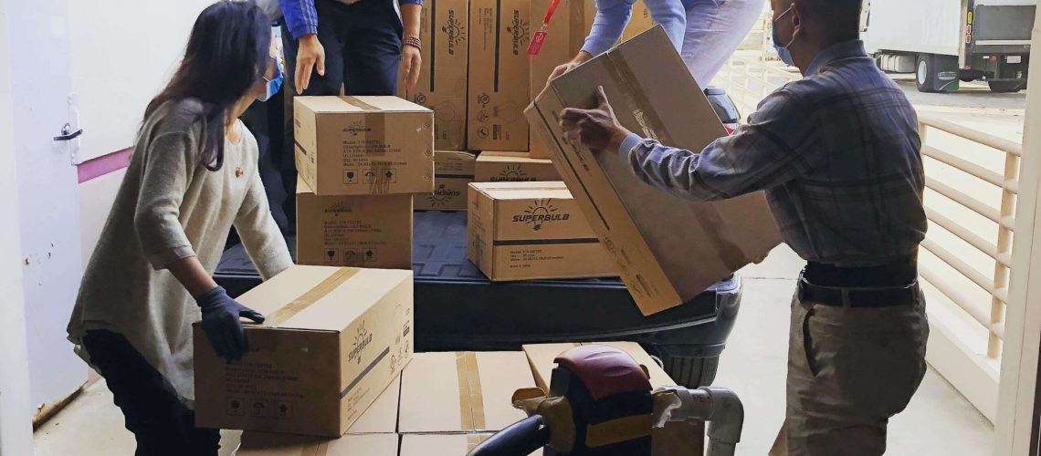 people carrying cardboard packaging boxes